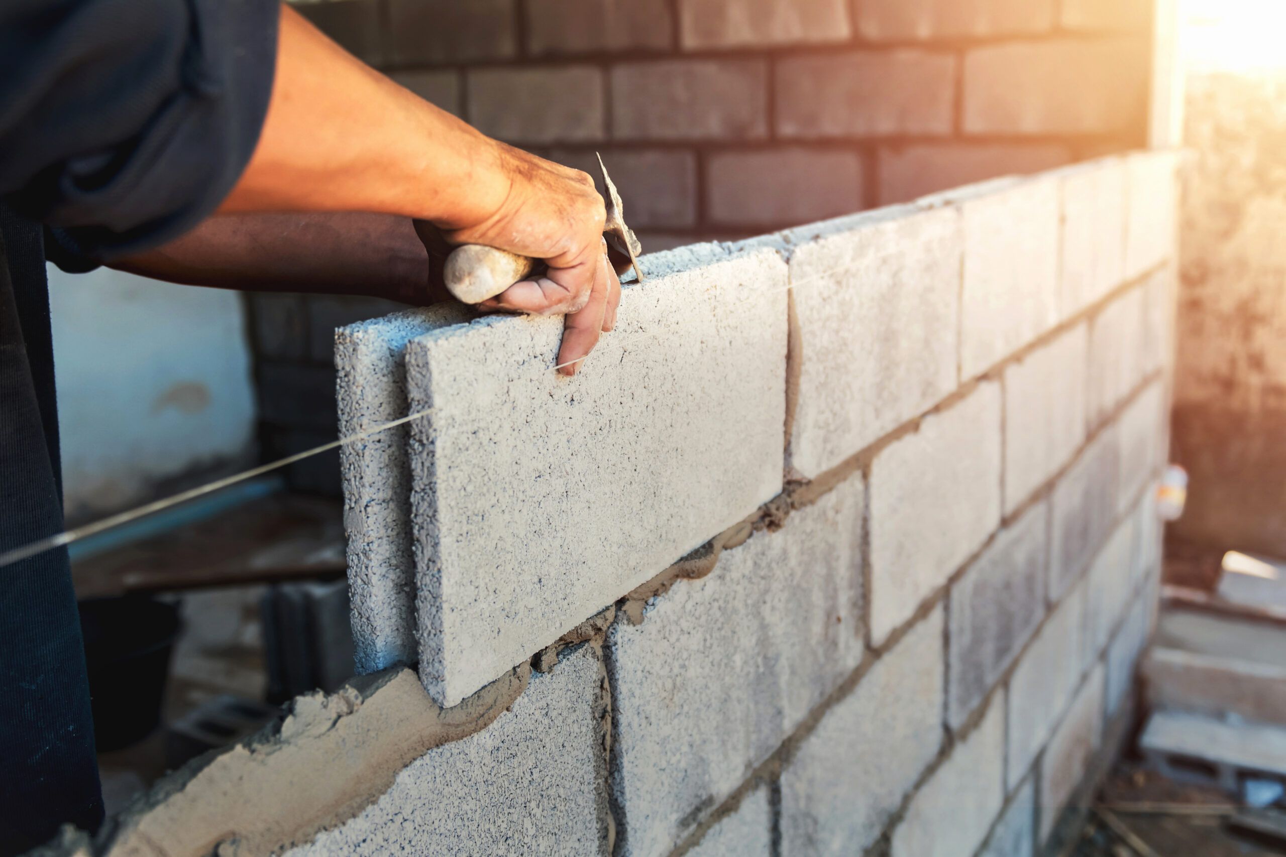 Ouvrier qui construit un mur de briques